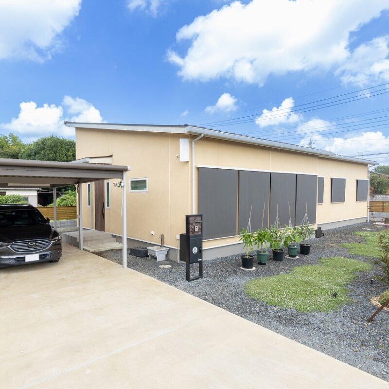 暖色系の外壁も左官職人であるご主人のお父様が仕上げたもの。夏は屋外シェードで太陽熱を遮り、快適な室温を保つ。