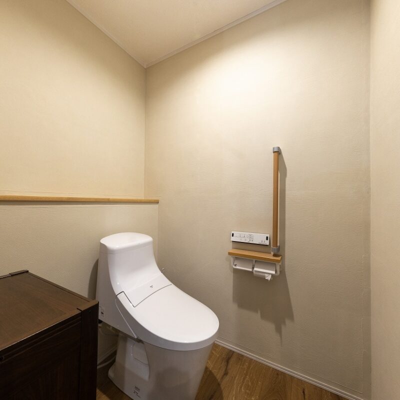 洗面室に隣接したトイレは、老後など介助が必要になった場合もゆったり使える広くてシンプルなつくり。入口横に置かれた棚はご主人のお手製。