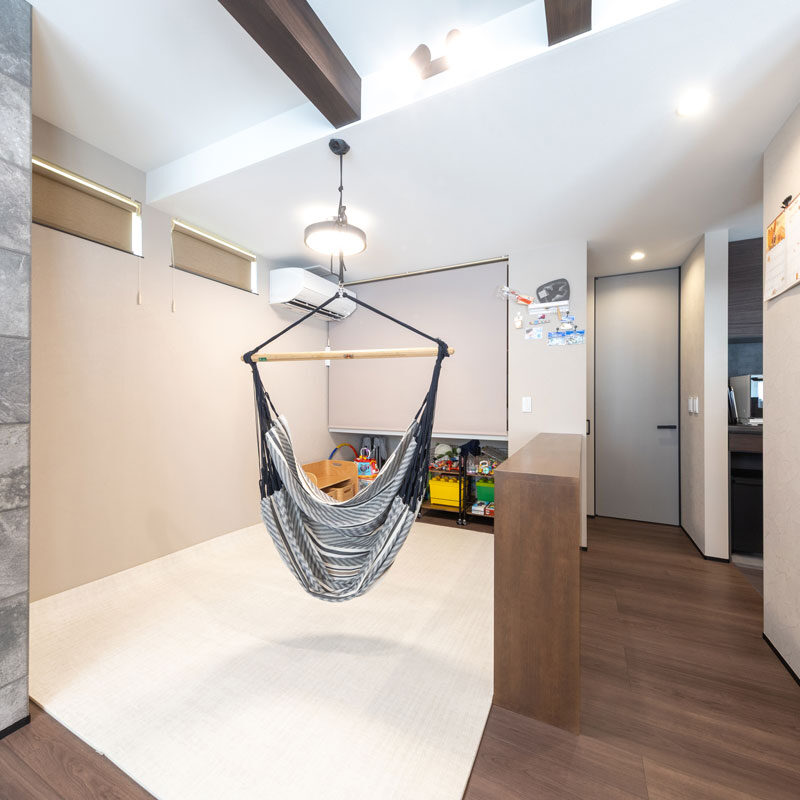 畳スペース（今は上からクッションフロアを敷設）には天井からハンモック。やんちゃ盛りのお子様には、たまらなくうれしい遊具。キッチン側の壁は全面マグネット仕様。畳スペースとリビングを仕切る腰高の本棚は、「男の子はまずよじ登って遊ぶじゃないですか（笑）。市販の棚だと動いたり、倒れたりが怖いので（」奥様）と、頑丈な造りつけにした。