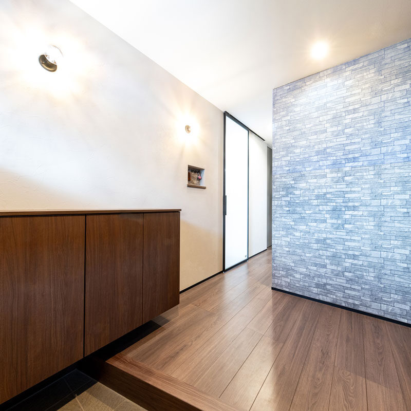 玄関ドア側から見たホール。右手はオープンクローゼットになっていて、コートやジャケット、かばんなど外出の支度品が収められている。目隠しに茶のストリングカーテンを選んだ奥様は慧眼。「 ロールスクリーンだと下からの巻き上げが面倒になって、使わなくなっちゃうなと思ったんです」