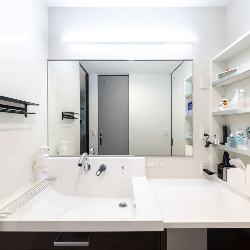 洗面台は既成のものを棚と洗面ボウル部分とに分けて、間に造作でカウンターを設置することで広いスペースを確保している。