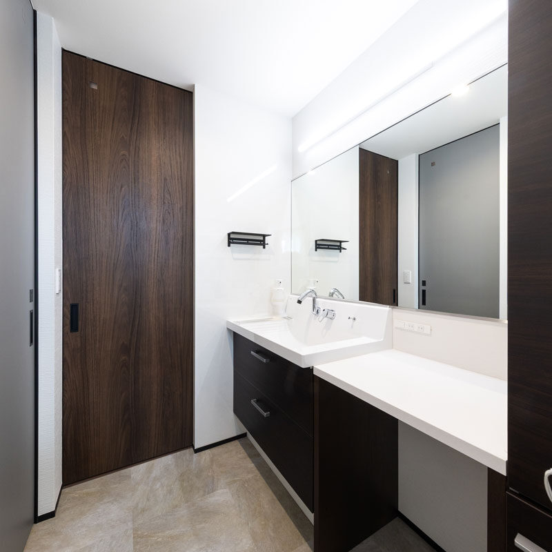 洗面台も将来の朝の混雑時を考慮して、超ワイドな作りに。二人並んで使っても余裕の広さ。ちなみに、Ｍ様邸は回遊動線が２つあるユニークなつくりになっていて、その１つがこちら。洗面台をぐるりと囲む動線はトイレ～風呂～脱衣洗濯室をつないでいて、家事に配慮されている。