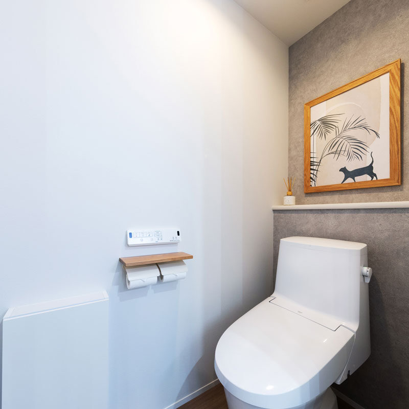 あえてタンク付きタイプを選択。「タンクレスはかっこいいけれど流す力が弱そう。しっかりと流すことで配管のトラブルが少なくなると思いました」（ご主人）。向かいに洗面台があるのでミニ手洗いは設けていない。絵のフレームとペーパーホルダーを木目で揃え、統一感をもたせた。