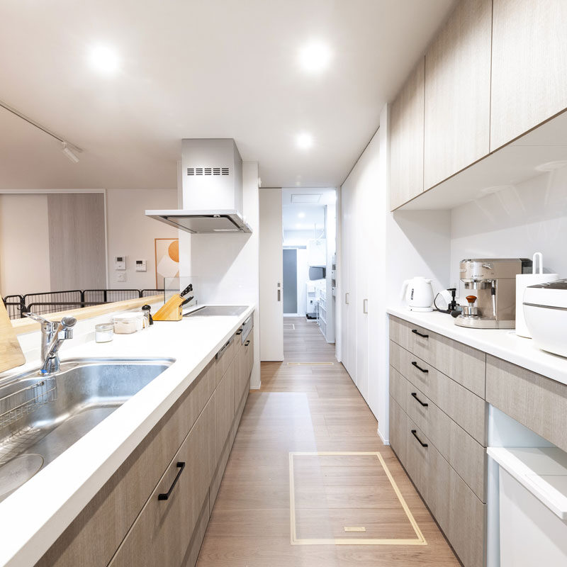 壁付けのキッチンだが、サイドを独立壁にすることで、アイランド型のような回遊式動線を実現した。現在はケージを置いているため通り抜けできないが、愛犬ファーストのご夫妻は「ケージは一時的なものなので」と笑顔。