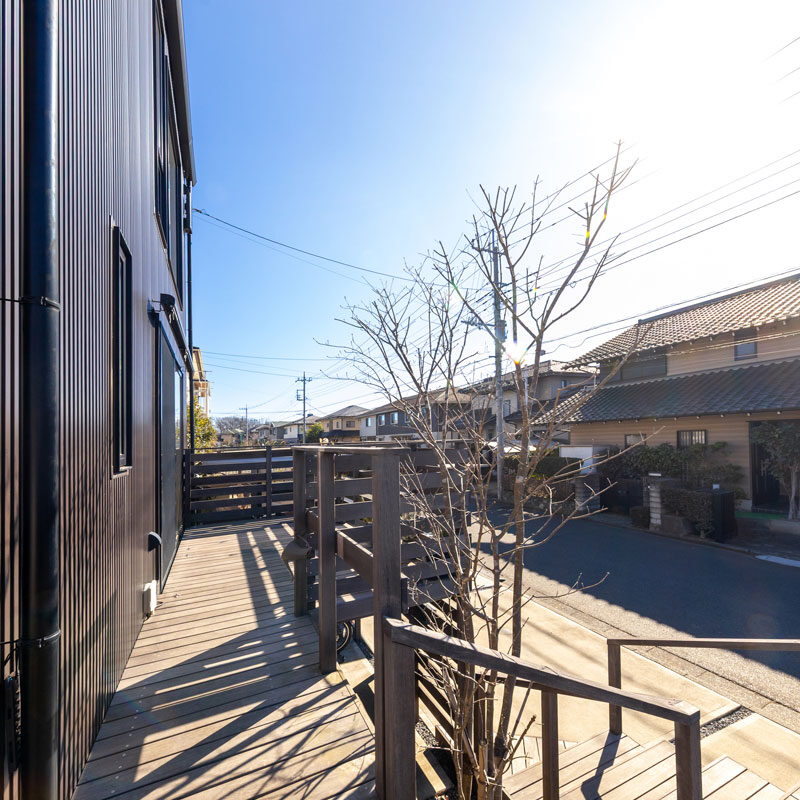 玄関ステップとつながるウッドデッキ。お茶の時間を楽しんだり、夏はプール遊びをしたりと活躍している。シンボルツリーは木肌が美しく、紅葉も楽しめるアオダモ。リビング内に彩りを添える。