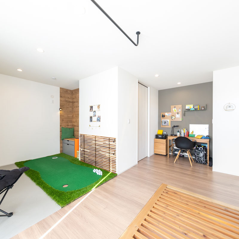 2階ホールを広く取り、家族の居場所をつくった。明るく風通しがよく、吹き抜けと高窓の開放感もあって、最高の居心地。シンプルなつくりのフリースペースで、用途に合わせて市販の家具やインテリアで機能を持たせた。天井のバーは物干し用。